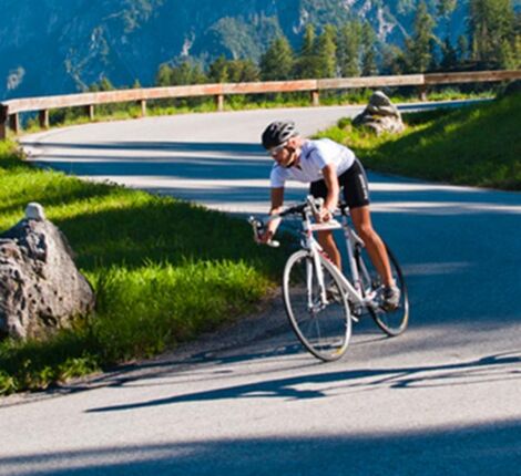 A racing cyclist rides his bike down a mountain road
