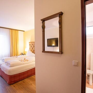 A hotel room at Hotel Agathawirt with a double bed, a balcony door and a bathroom
